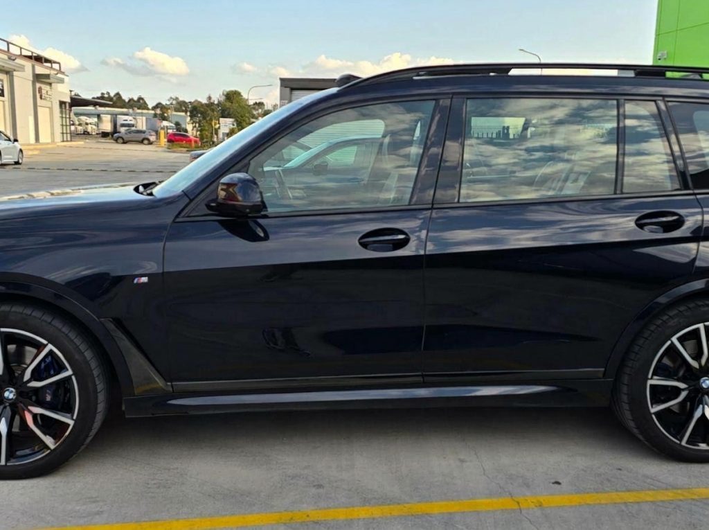 Blue 2019 BMW X7 xDrive30d, side profile, available for hire in Sydney