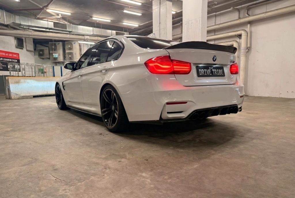 White 2016 BMW M3 Competition F80, rear three-quarter view, available for hire in Sydney
