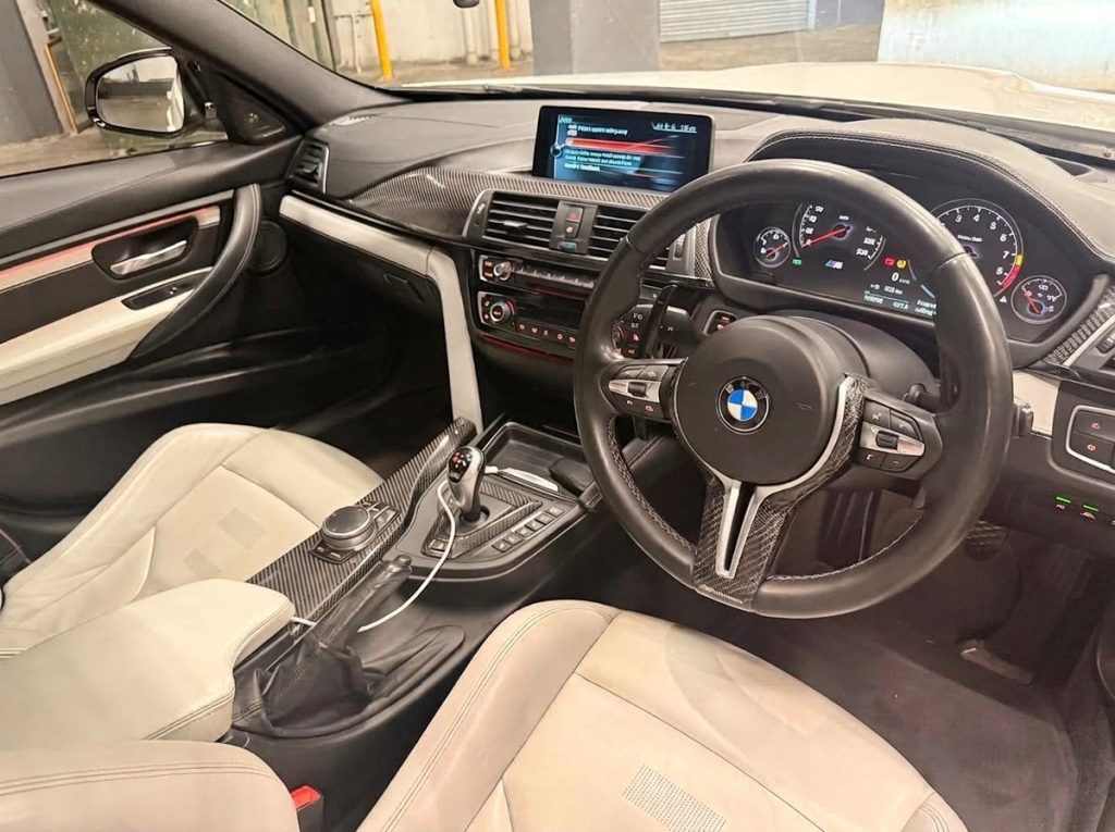 Dashboard of the white 2016 BMW M3 Competition F80, available for hire in Sydney