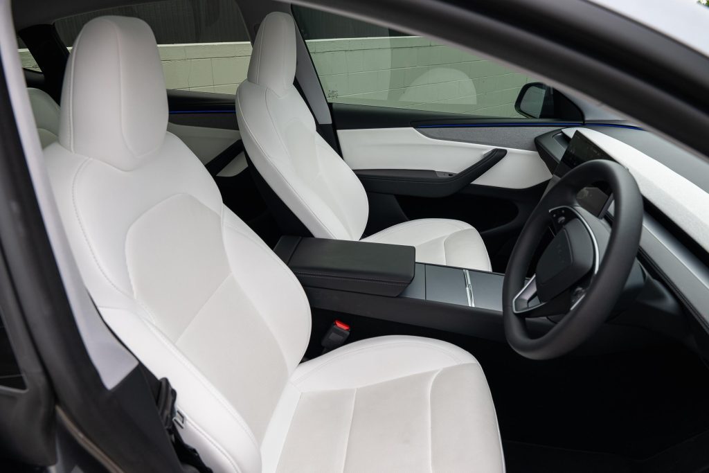 Front seats of the silver 2025 Tesla Model Y RWD, available for hire in Sydney