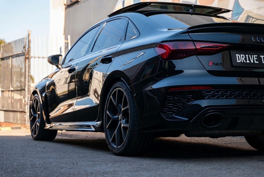 Black 2022 Audi RS 3 Sportback, rear three-quarter view, available for hire in Sydney